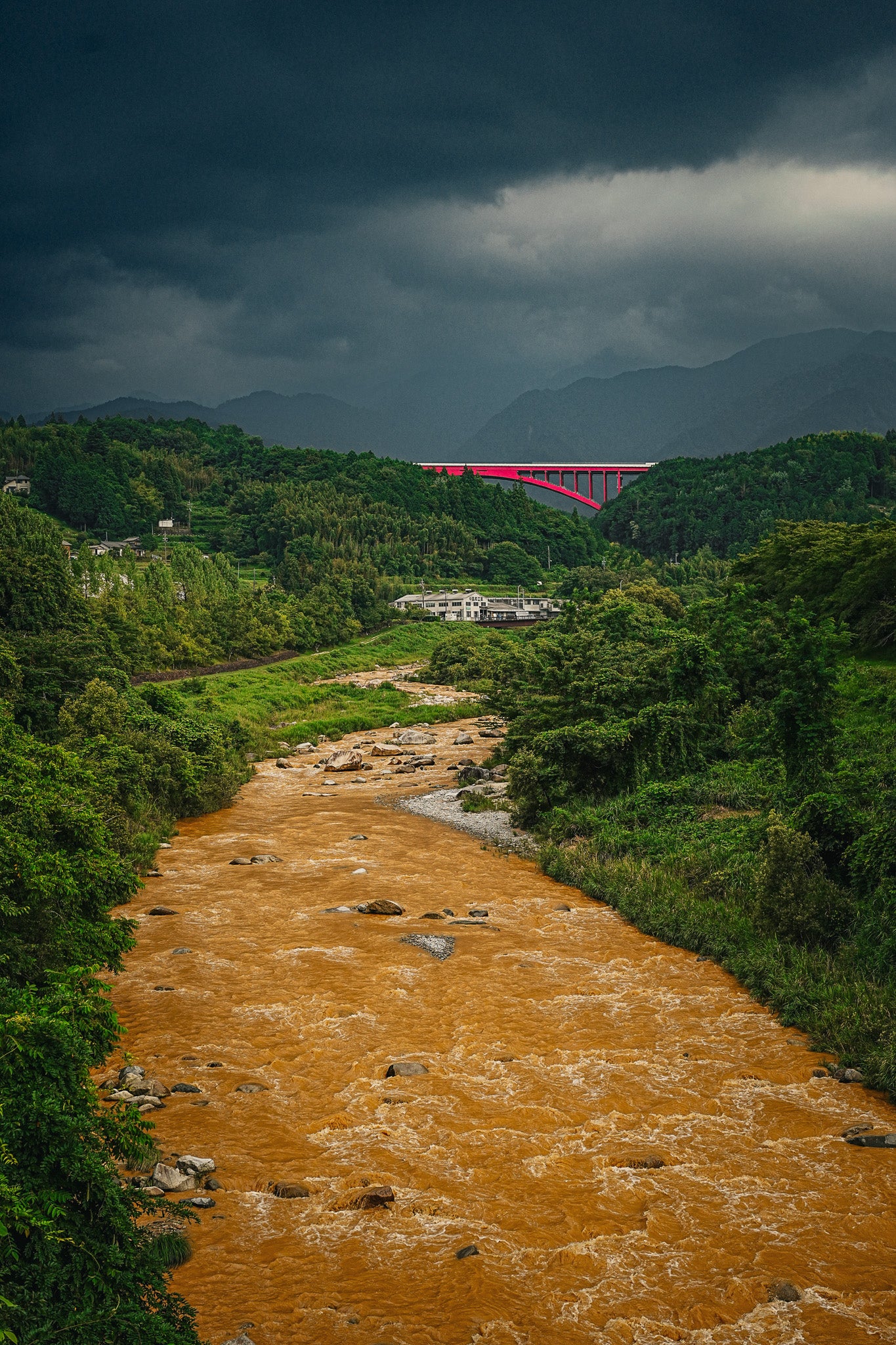 木曽谷の濁流と赤い橋